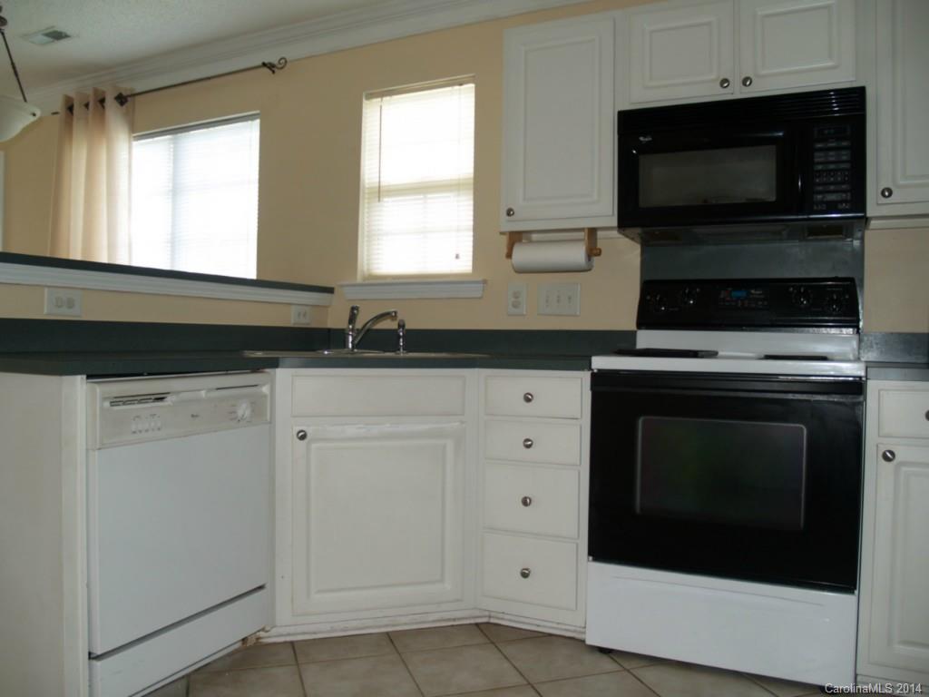 10402 Gold Pan Road Charlotte, NC 28215 - Photo 6 of 21 a kitchen with white cabinets and appliances