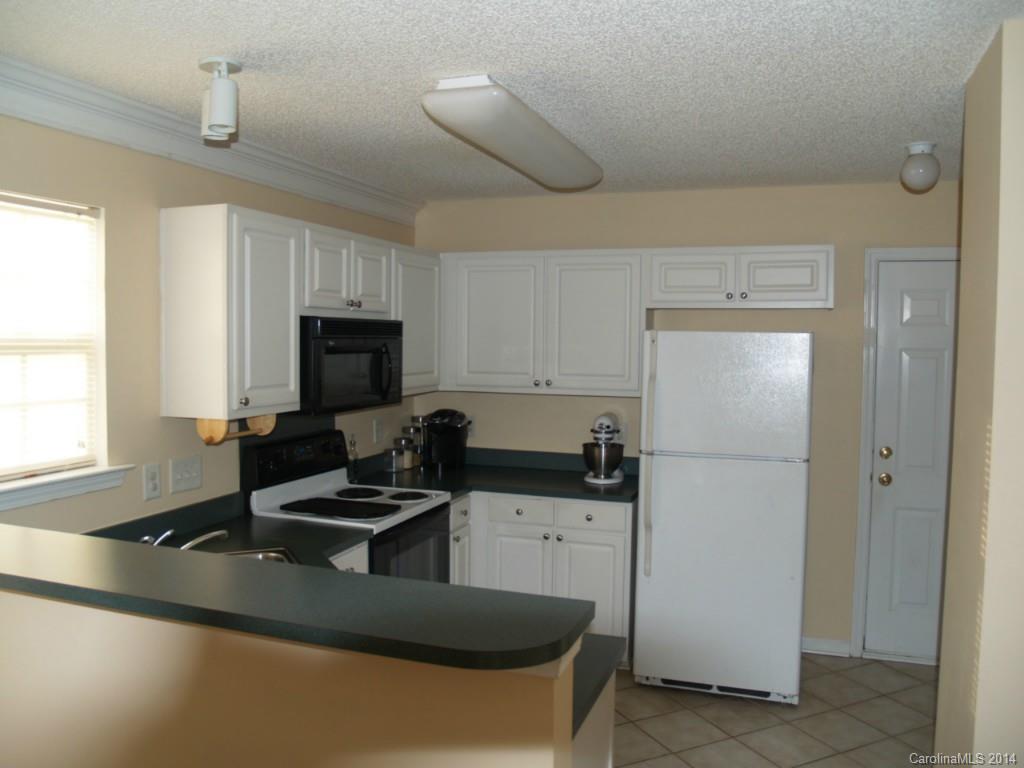 10402 Gold Pan Road Charlotte, NC 28215 - Photo 7 of 21 a kitchen with a refrigerator a stove a sink and a microwave