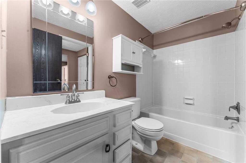 113 Forest Drive Seven Fields, PA 16046 - Photo 19 of 32 a bathroom with a toilet a sink a mirror a bathtub and vanity