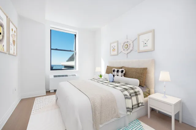 a bedroom with a bed and a potted plant