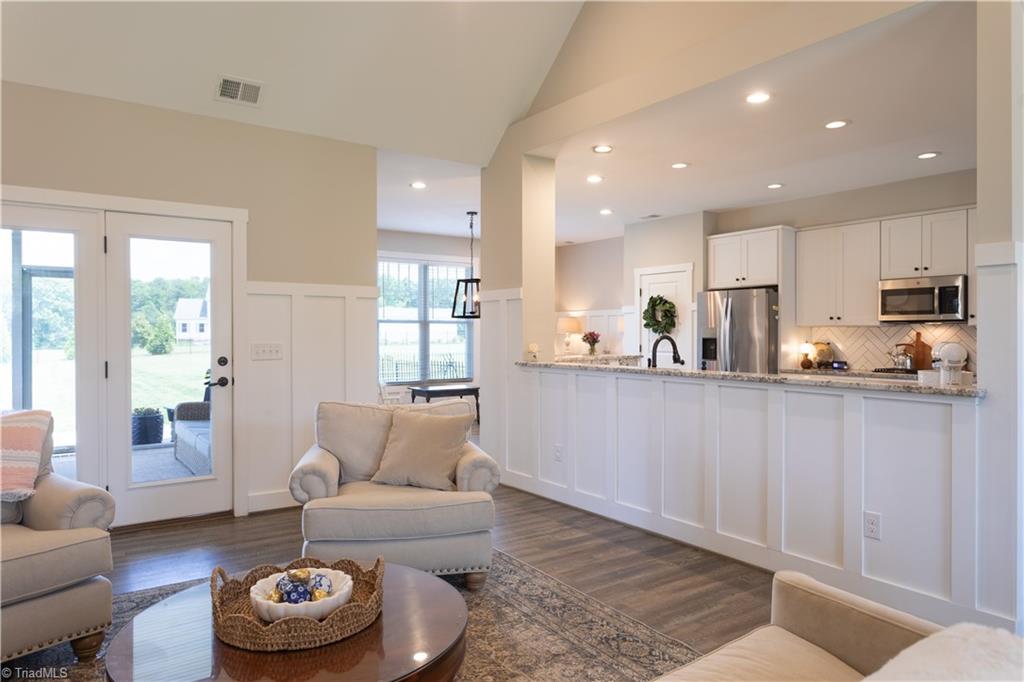 393 Scout Road Lexington, NC 27292 - Photo 9 of 47 Panning around in the great room with a view of the kitchen and breakfast nook. Again, access the screened porch is straight ahead, over to the left. The home has a lovely custom feel and cozy vibe.