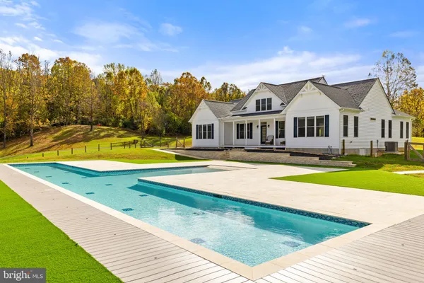 a view of an house with swimming pool and yard