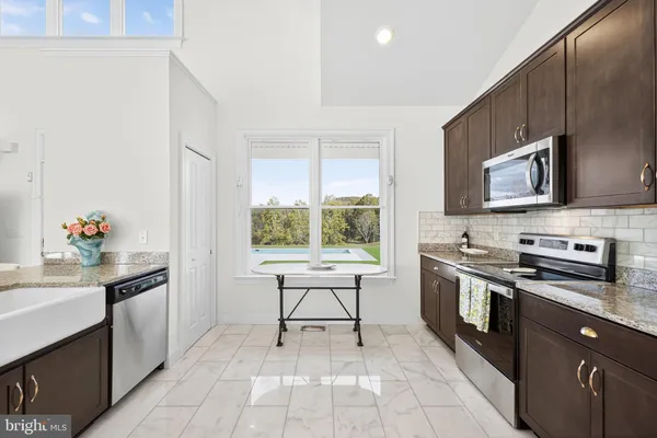 a kitchen with stainless steel appliances a stove sink microwave and cabinets