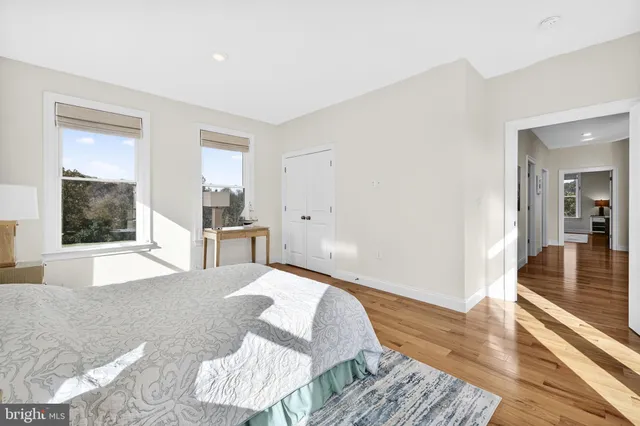 a spacious bedroom with a bed and wooden floor