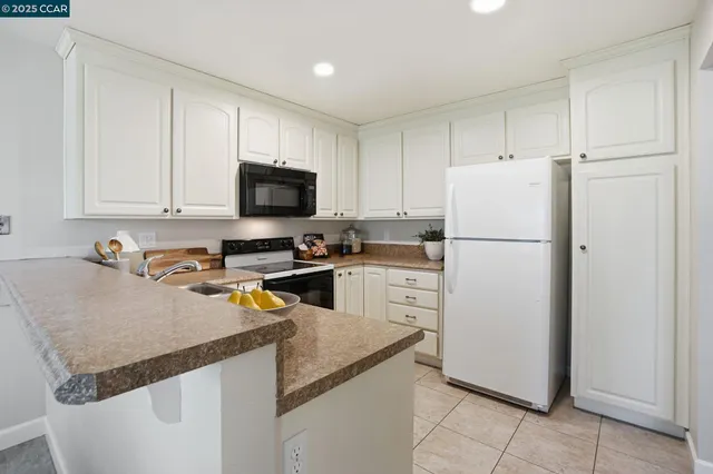 a kitchen with a refrigerator and a stove top oven