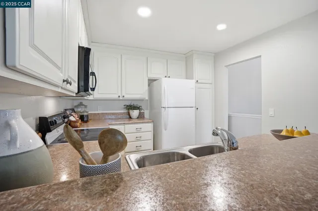 a kitchen with refrigerator and cabinets