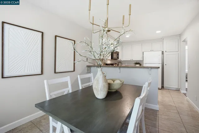 a kitchen with a table chairs and a refrigerator