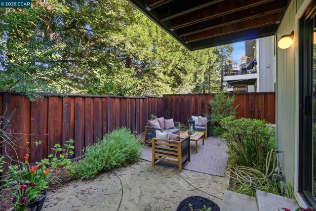 a patio with a table and chairs and potted plants