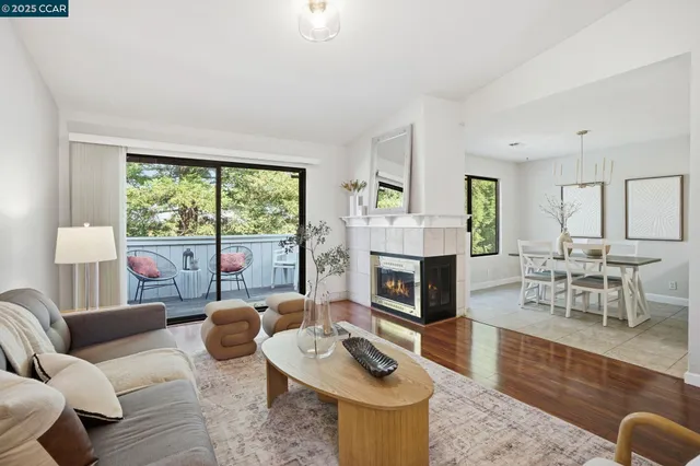 a living room with furniture fireplace and a large window