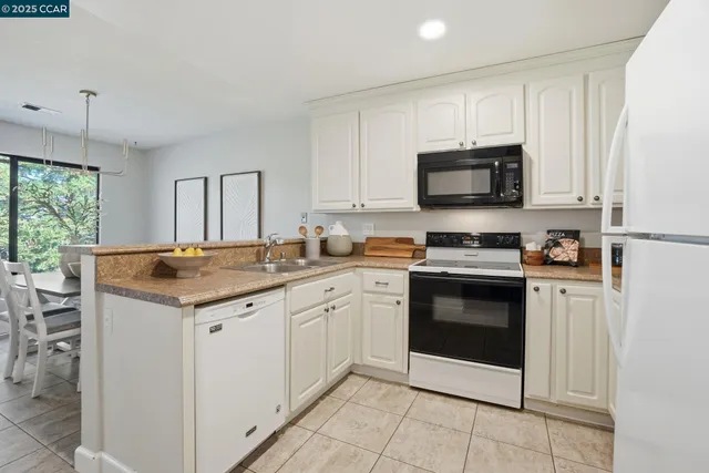 a kitchen with granite countertop a sink and steel appliances