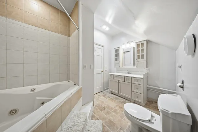 a bathroom with a sink a toilet a mirror a bathtub and shower