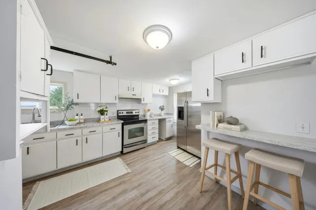 a view of a kitchen with wooden floor and electronic appliances