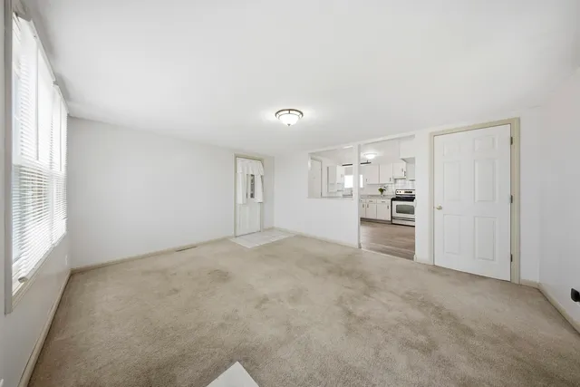 a view of a livingroom with wooden furniture and windows