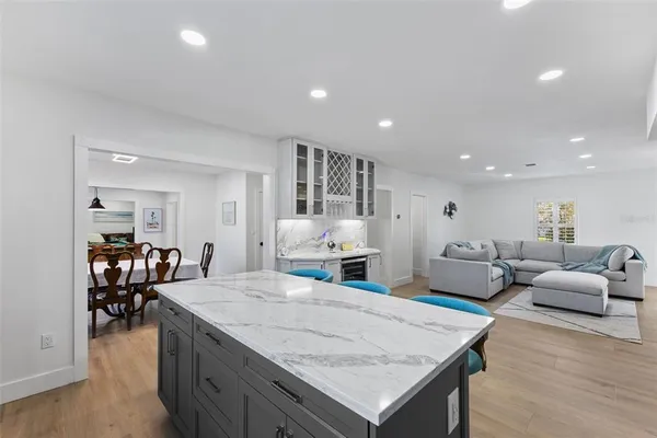 a kitchen with stainless steel appliances granite countertop a refrigerator a stove a sink dishwasher and white cabinets with wooden floor