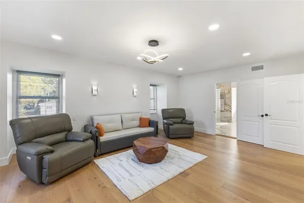 a kitchen with stainless steel appliances kitchen island granite countertop a table chairs sink and cabinets