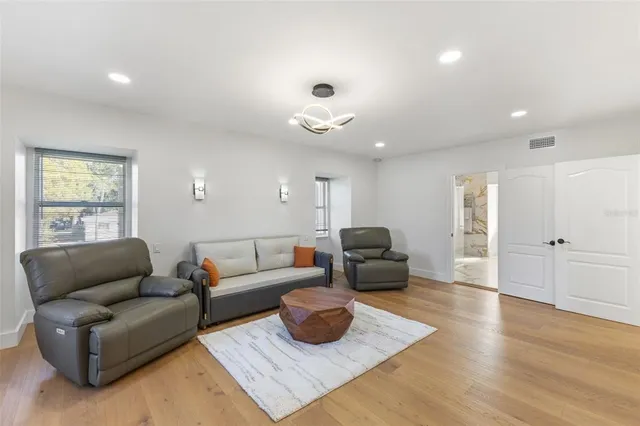 a kitchen with stainless steel appliances kitchen island granite countertop a table chairs sink and cabinets