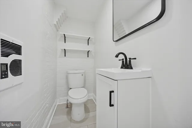 a bathroom with a toilet sink and mirror