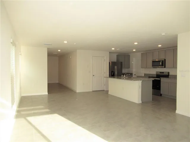 a view of kitchen with kitchen island a sink stainless steel appliances and cabinets