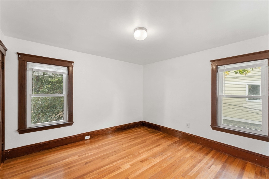 25 Tip Top Street, Unit 2 Boston, MA 02135 - Photo 18 of 35 a view of empty room with wooden floor and fan
