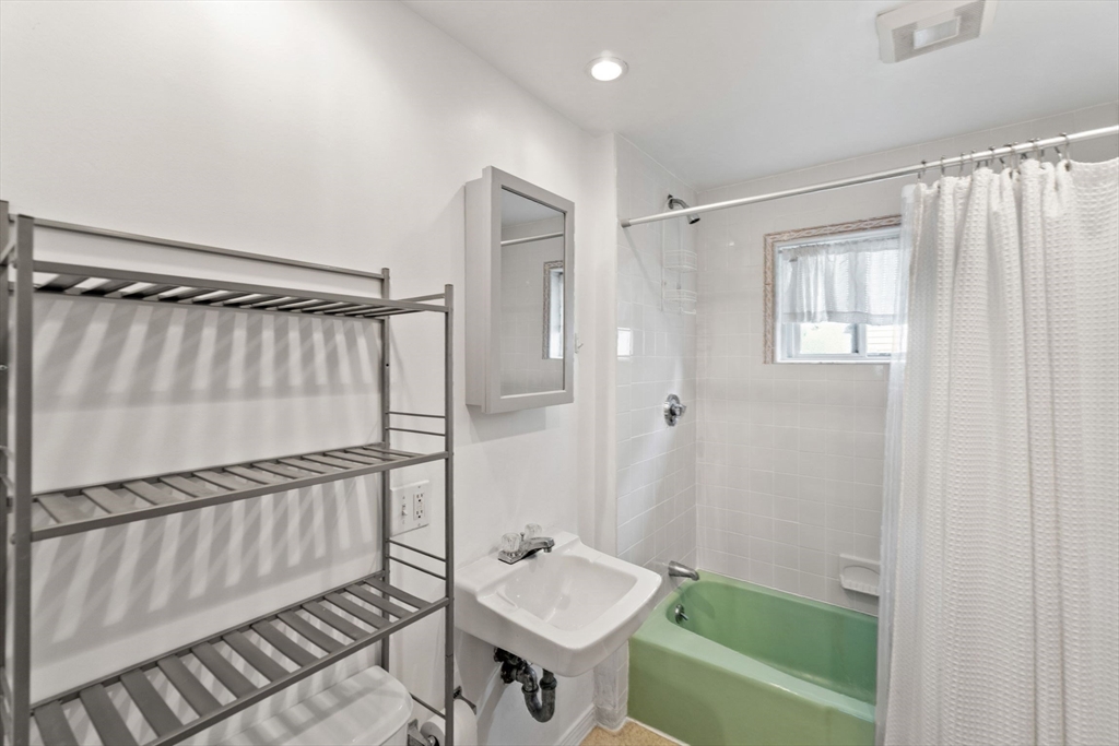 25 Tip Top Street, Unit 2 Boston, MA 02135 - Photo 19 of 35 a bathroom with a sink a toilet and a bathtub