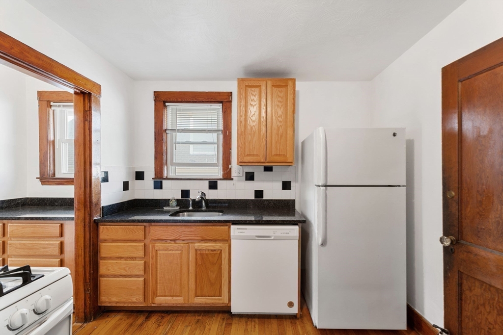 25 Tip Top Street, Unit 2 Boston, MA 02135 - Photo 20 of 35 a kitchen with a refrigerator sink and cabinets