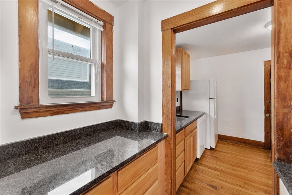 25 Tip Top Street, Unit 2 Boston, MA 02135 - Photo 22 of 35 a view of a hallway with wooden floor and staircase