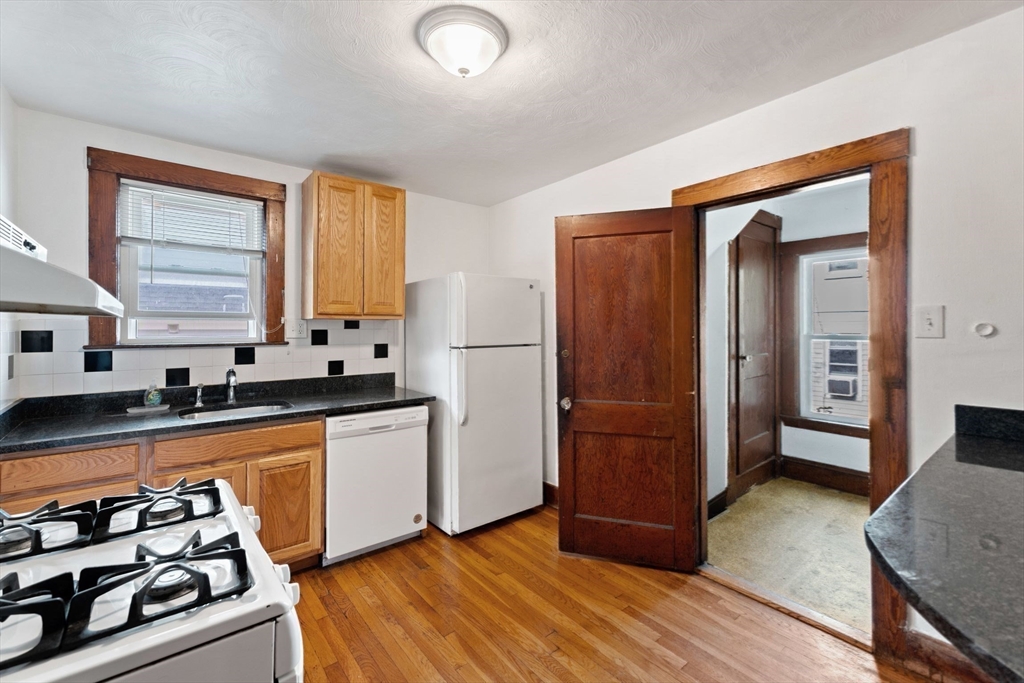 25 Tip Top Street, Unit 2 Boston, MA 02135 - Photo 23 of 35 a kitchen with stainless steel appliances granite countertop a refrigerator and a stove top oven