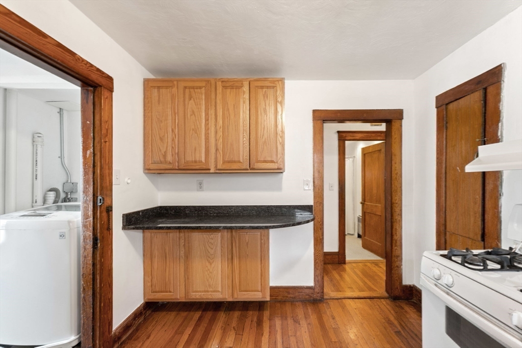 25 Tip Top Street, Unit 2 Boston, MA 02135 - Photo 24 of 35 a kitchen with wooden floors and white appliances