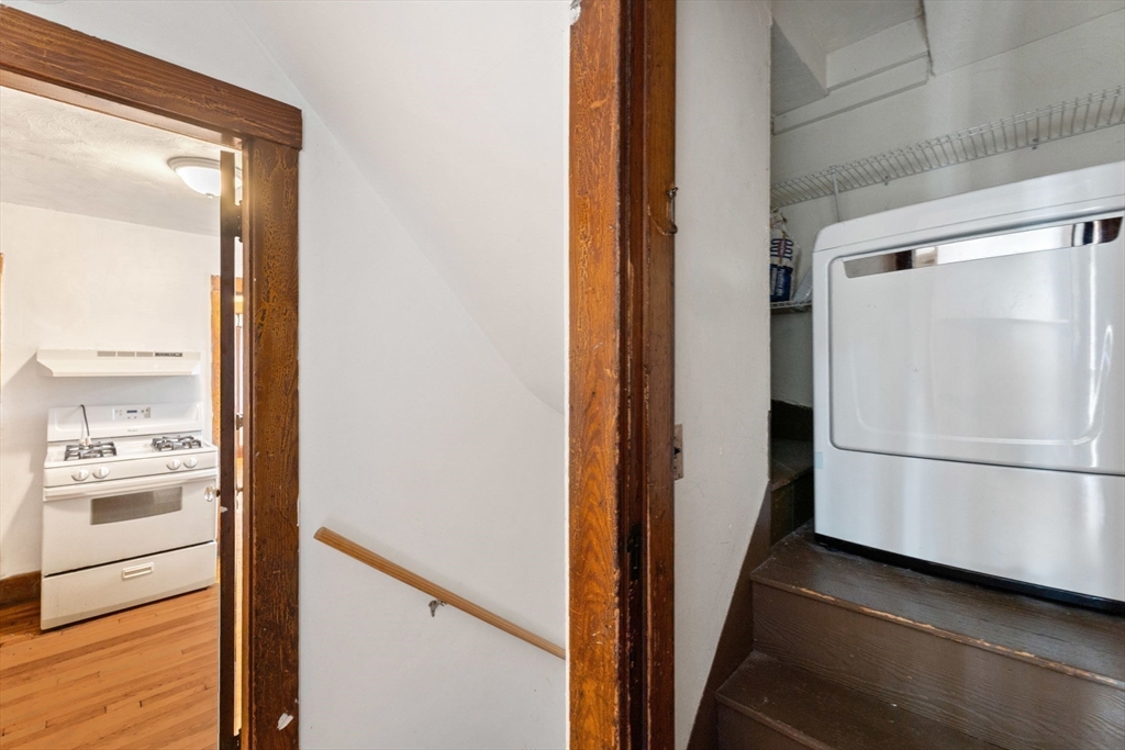 25 Tip Top Street, Unit 2 Boston, MA 02135 - Photo 25 of 35 a view of a hallway with white cabinets and wooden floor