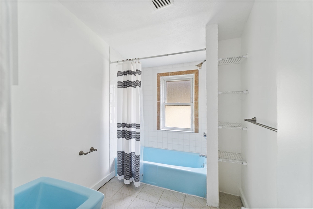 25 Tip Top Street, Unit 2 Boston, MA 02135 - Photo 28 of 35 a bathroom with a tub a sink and a shower