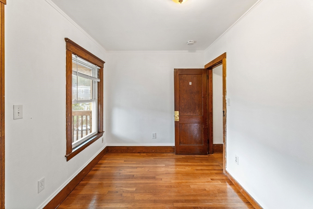 25 Tip Top Street, Unit 2 Boston, MA 02135 - Photo 4 of 35 a view of an empty room with wooden floor and a window