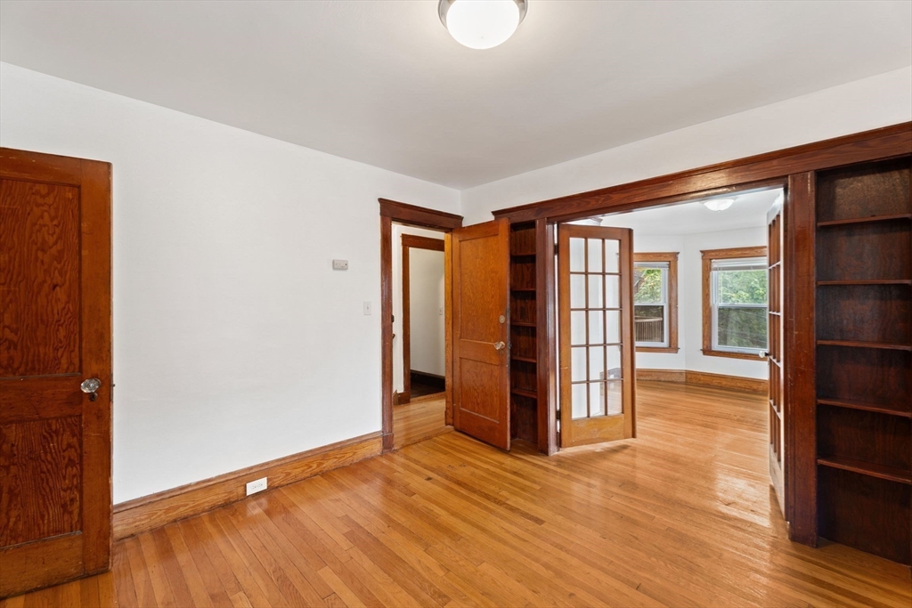 25 Tip Top Street, Unit 2 Boston, MA 02135 - Photo 6 of 35 an empty room with wooden floor and windows