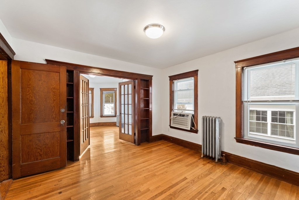 25 Tip Top Street, Unit 2 Boston, MA 02135 - Photo 7 of 35 a view of an empty room with window and wooden floor