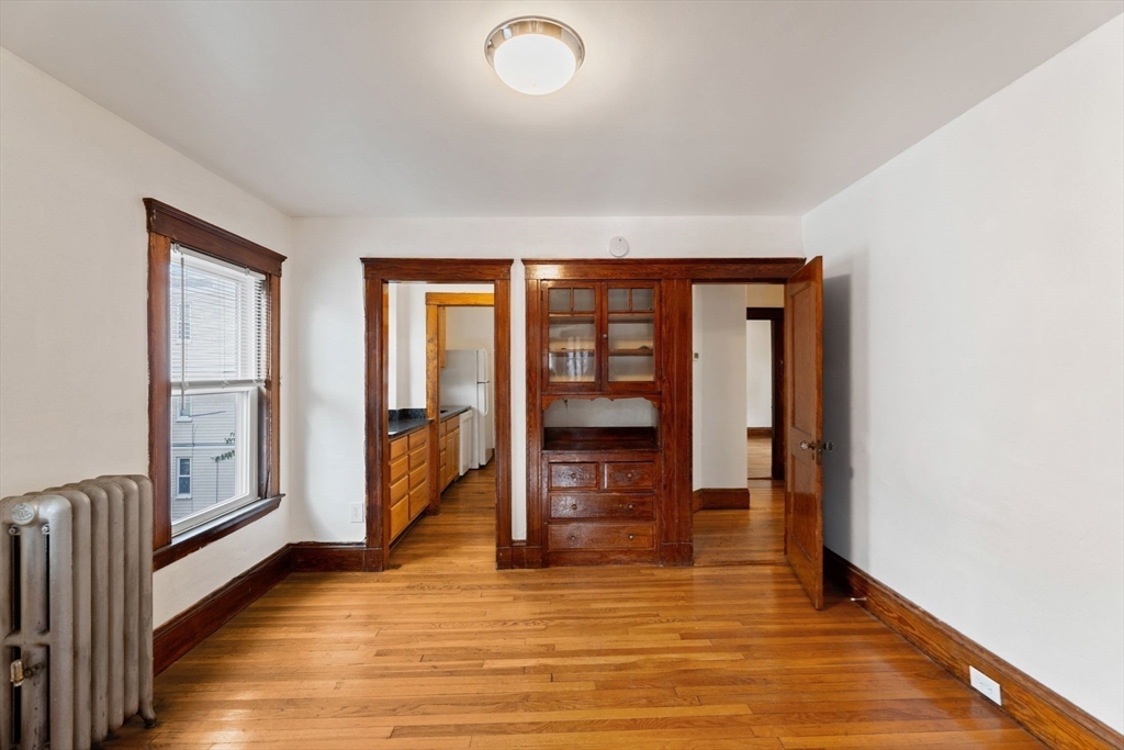 25 Tip Top Street, Unit 2 Boston, MA 02135 - Photo 9 of 35 a view of an empty room with window and wooden floor