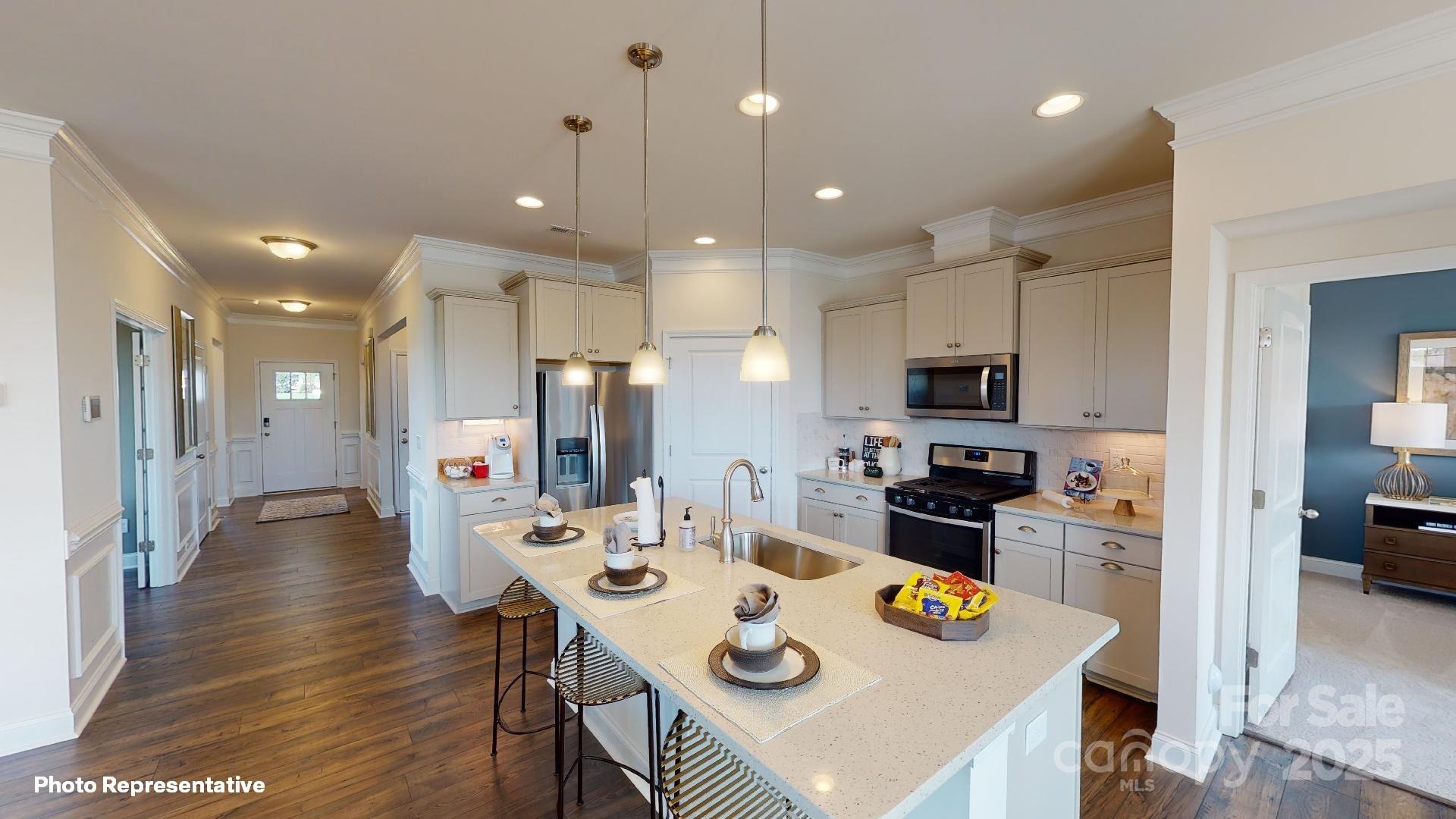 7653 Bainbridge Road Sherrills Ford, NC 28673 - Photo 12 of 25 a kitchen with stainless steel appliances kitchen island granite countertop a refrigerator a stove a sink a dining table and chairs with wooden floor