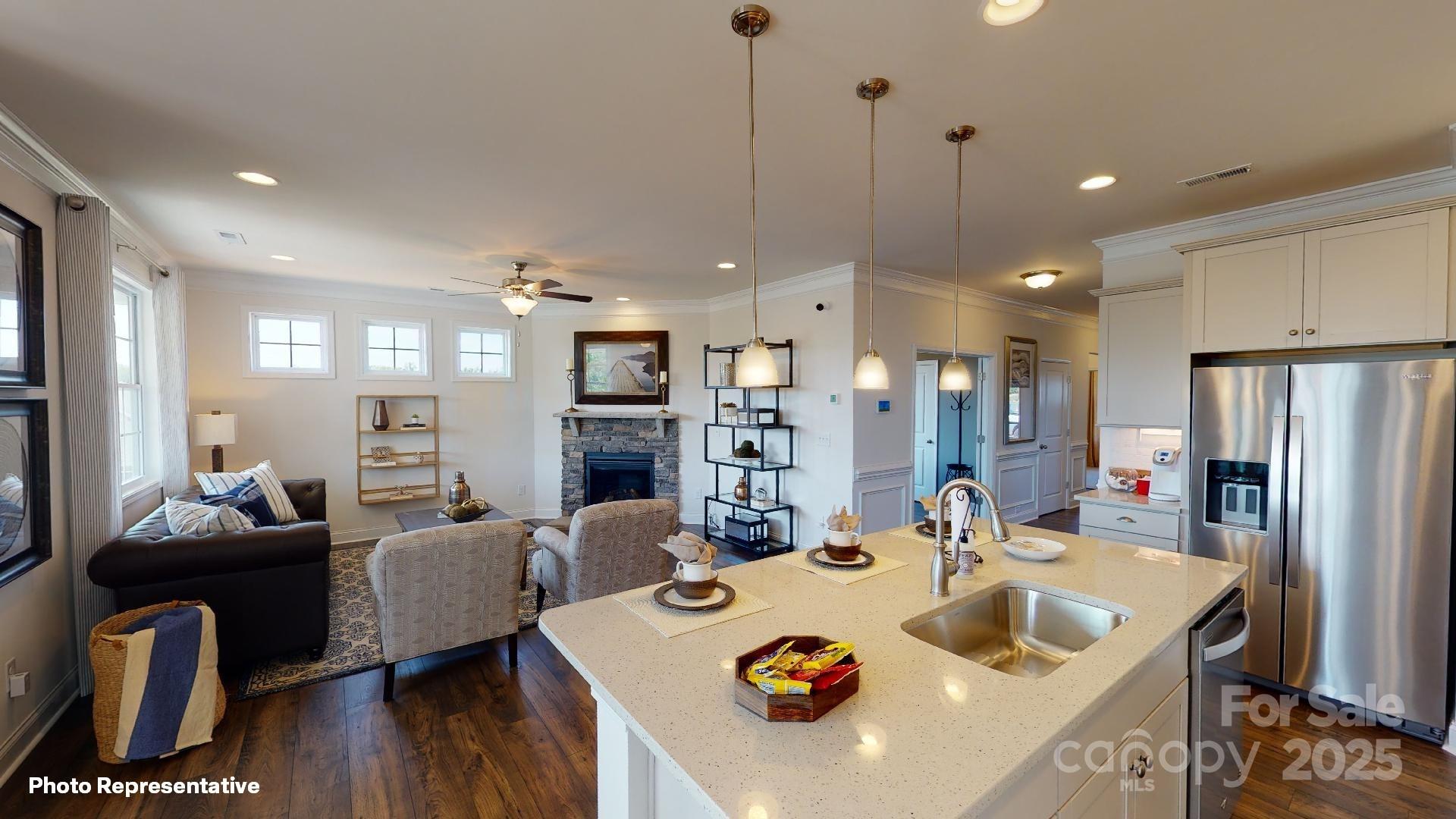 7653 Bainbridge Road Sherrills Ford, NC 28673 - Photo 16 of 25 a large kitchen with kitchen island a refrigerator a stove a sink a dining table and chairs with wooden floor