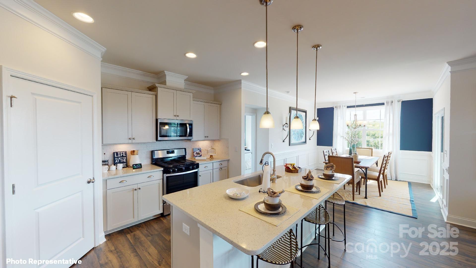 7653 Bainbridge Road Sherrills Ford, NC 28673 - Photo 10 of 25 a open kitchen with stainless steel appliances granite countertop a stove a sink a dining table and chairs with wooden floor