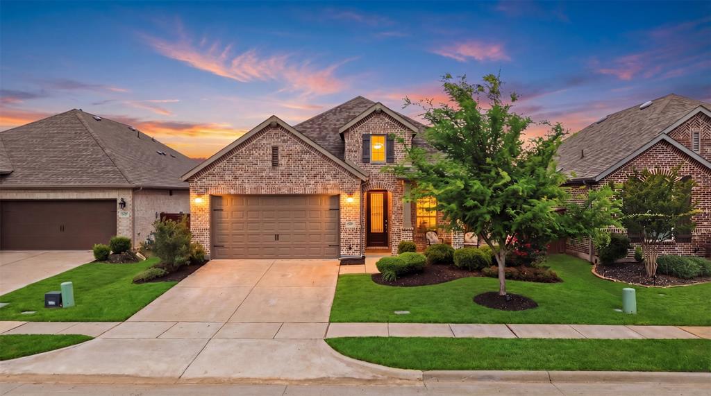 1429 Eclipse Road Aubrey, TX 76227 - Photo 1 of 37 The property features a brick facade, a well-maintained front lawn, a paved driveway, and a two-car garage