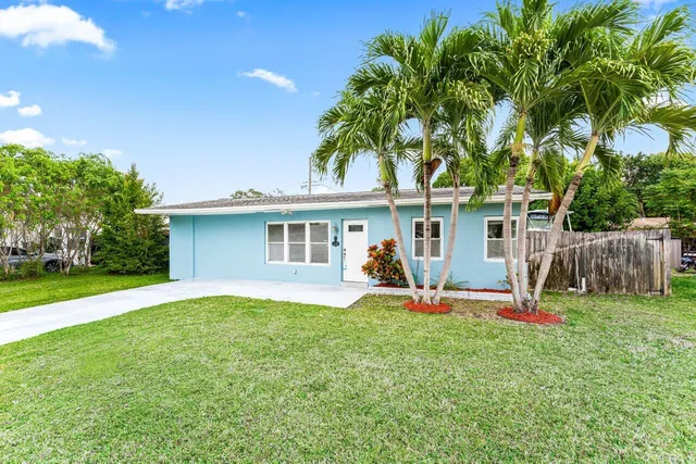 a view of a house with backyard and a tree