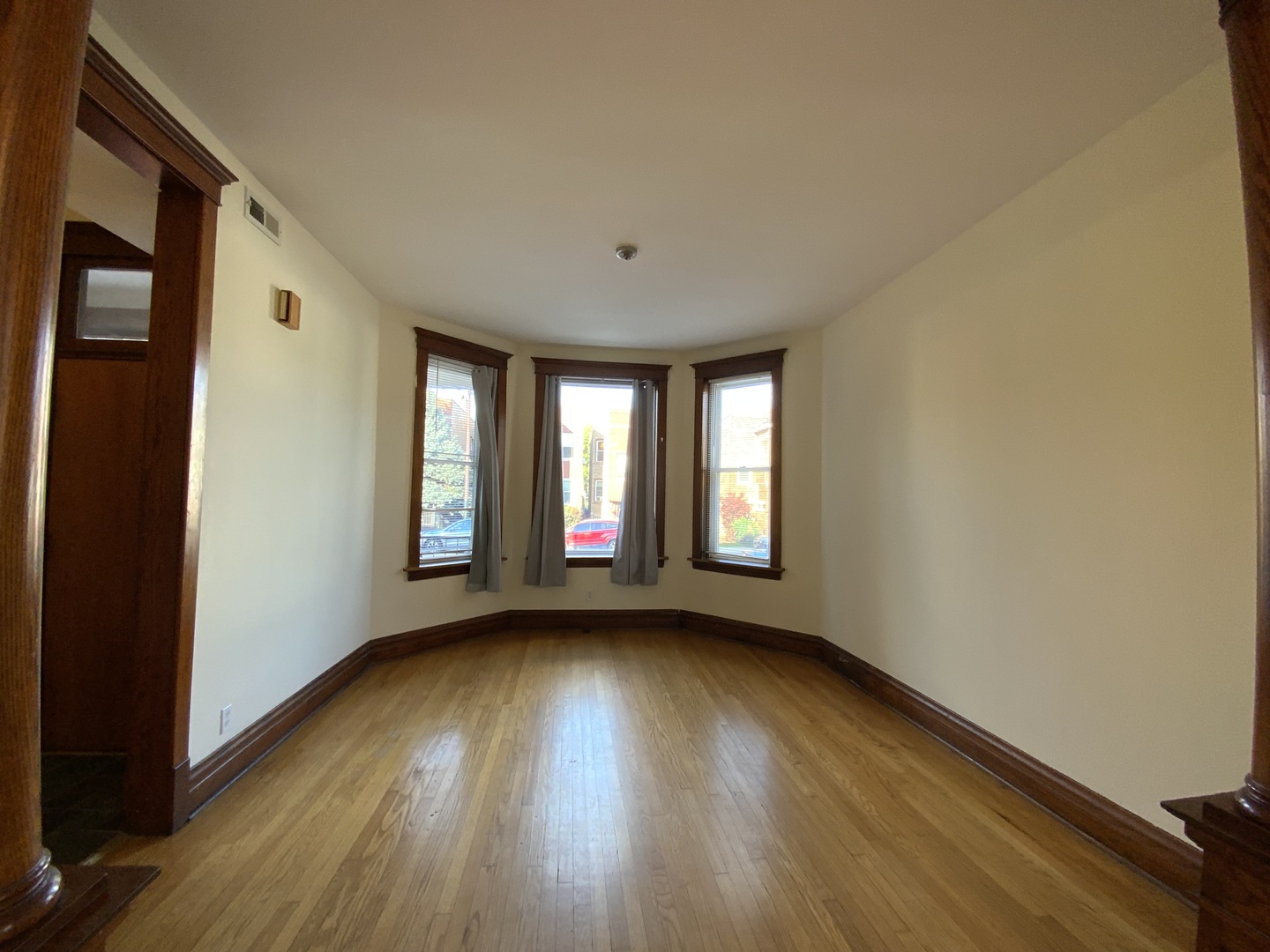 3116 North Elston Avenue, Unit 1 Chicago, IL 60618 - Photo 3 of 16 a view of an empty room with wooden floor and a window
