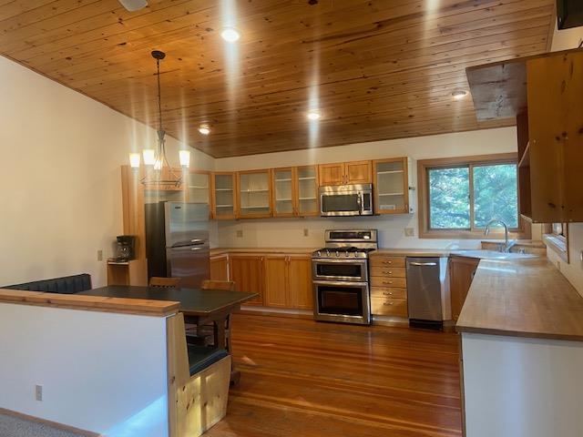 67 Hill Street Mammoth Lakes, CA 93546 - Photo 14 of 24 Kitchen with glass insert cabinets, hanging light fixtures, stainless steel appliances, dark wood-style floors, and wooden ceiling