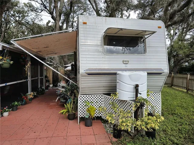 a view of a chairs and table in the back yard of the house