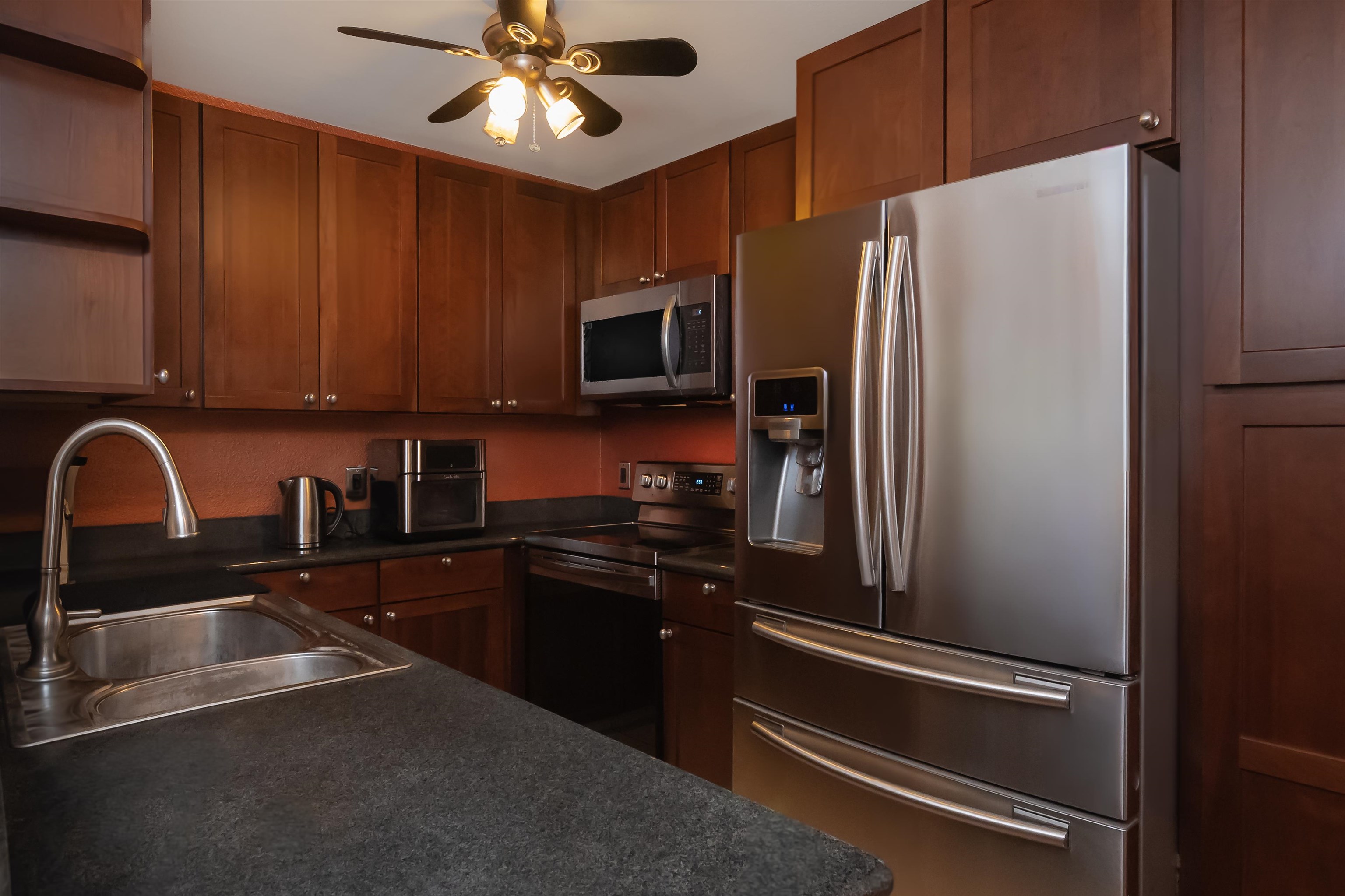 140 Uwapo Road, Unit 29101 Kihei, HI 96753 - Photo 4 of 13 a kitchen with a refrigerator a sink and cabinets