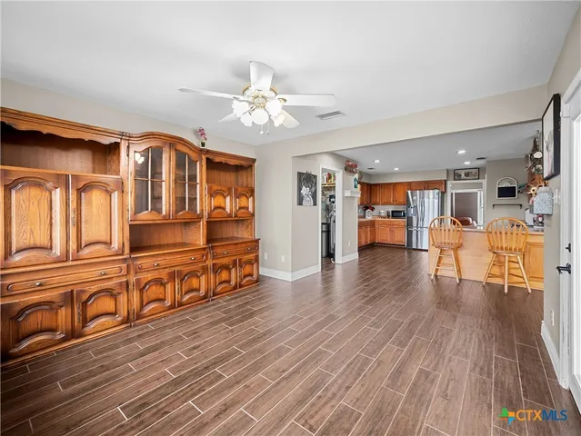 a living room with furniture wooden floor and a kitchen view
