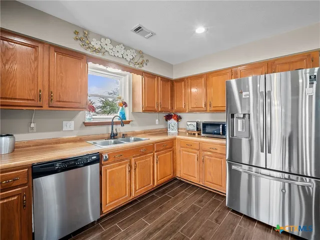 a kitchen with stainless steel appliances granite countertop a refrigerator sink and cabinets