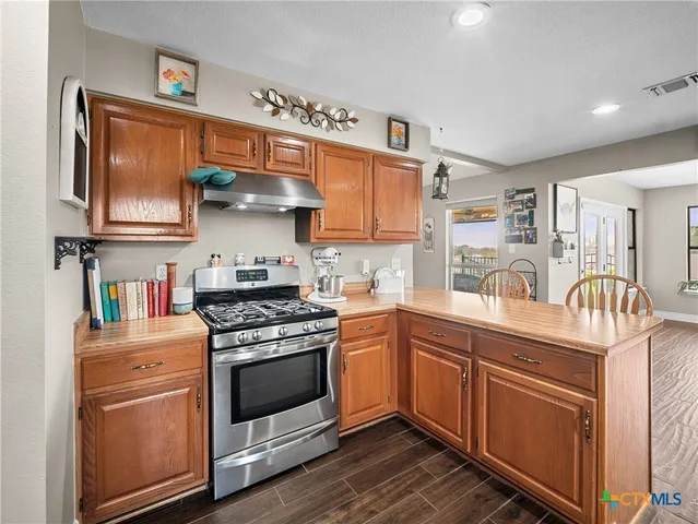 a kitchen with stainless steel appliances granite countertop a stove and a sink