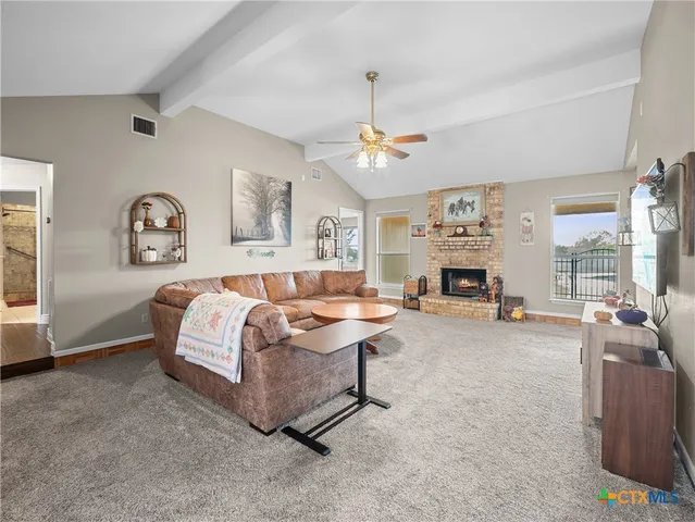 a living room with furniture a wall paintings and a lamp