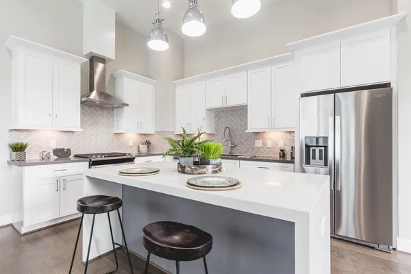a kitchen with stainless steel appliances a table and chairs in it