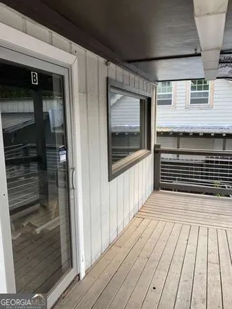 a view of a balcony with wooden floor and door