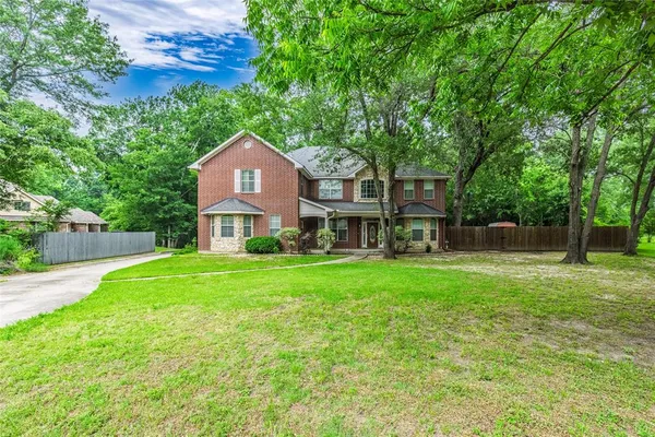 a front view of a house with a yard and trees